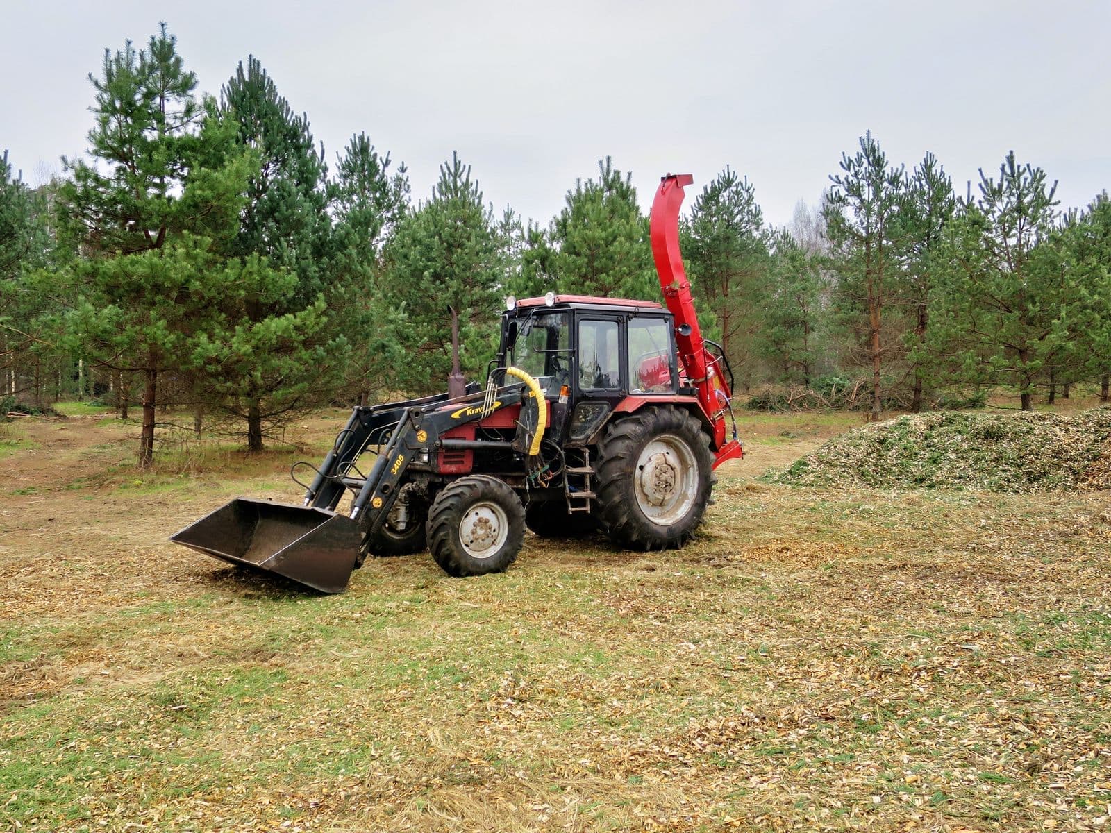 Tractor with a mulching attachment in a clearing