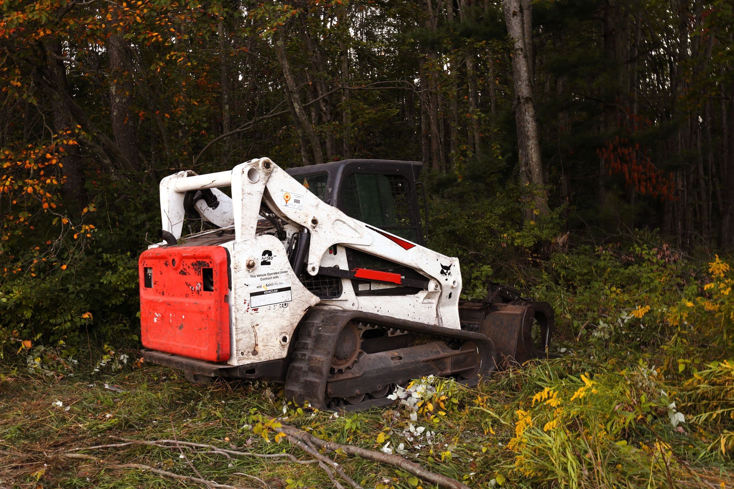 Forestry mulching head on a tracked skid steer working through brush